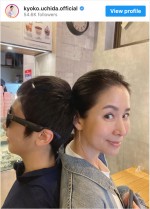 長男と背中合わせに並んで笑顔を見せる内田恭子　※「内田恭子」インスタグラム