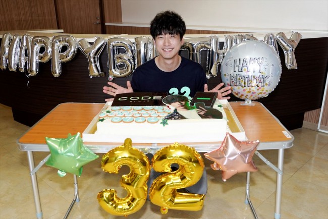 ドラマ『CODE―願いの代償―』より、誕生日サプライズケーキの前で笑顔を見せる坂口健太郎