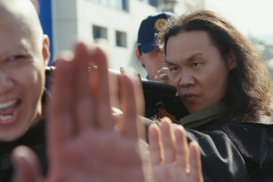 日曜劇場『VIVANT』第21話　周浩然（シュウ ハオラン）の後頭部に銃を突き付け威嚇するチンギス